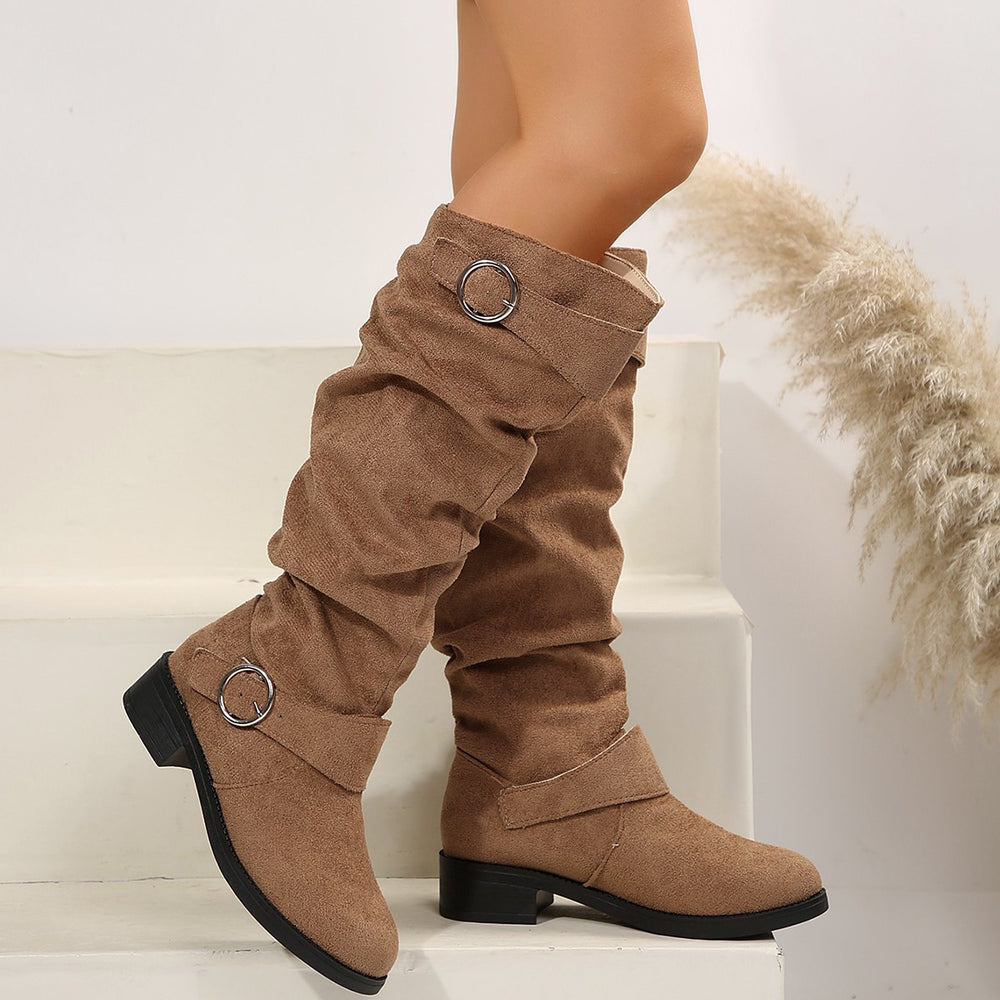 Brown knee-high boots with metal rings on a white background