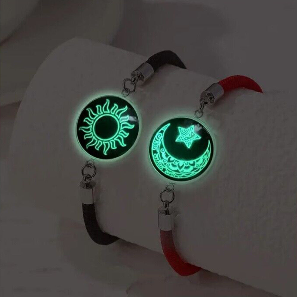 Glowing sun and moon designs on bracelets with black and red straps.