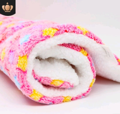 Rolled-up colorful blanket with white interior on a light pink background