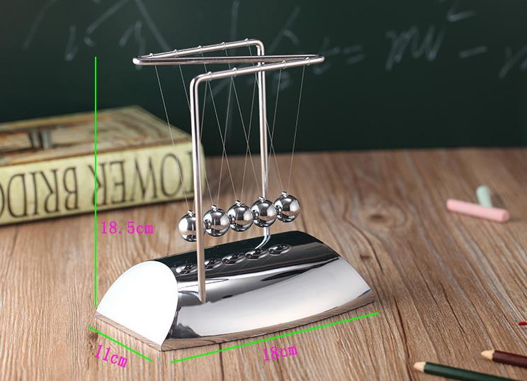 Metal Newton's cradle on a wooden surface with measurements displayed