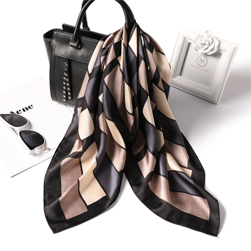 Patterned scarf with black handbag, sunglasses, and white box on a white background