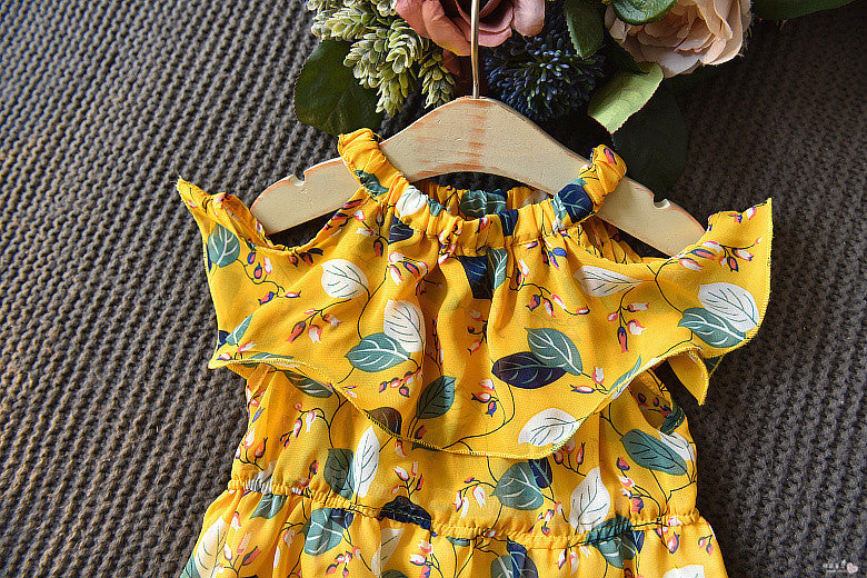 Yellow floral dress on a hanger against a textured brown background