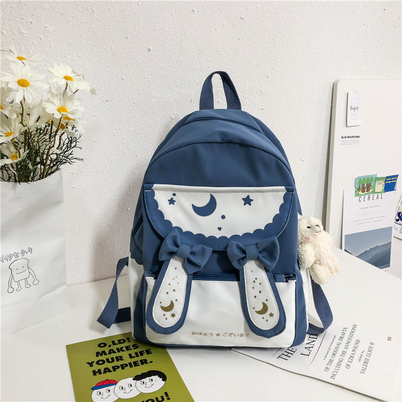 Blue and white backpack with decorative elements on a surface with a light background