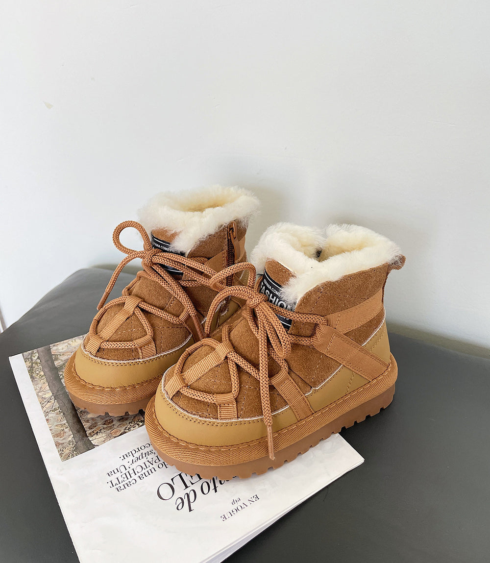 Pair of brown suede boots with white fur lining on a gray surface.
