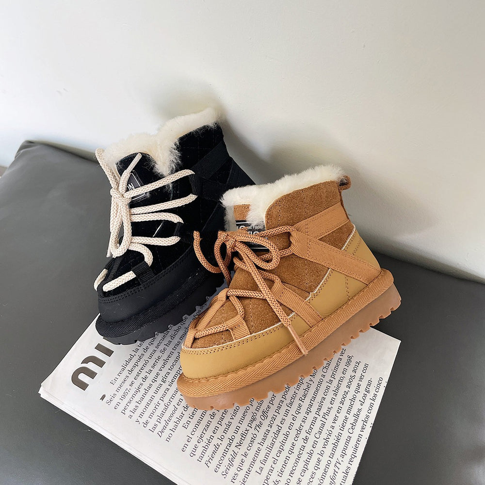 Black and brown winter boots with fur lining on a newspaper.