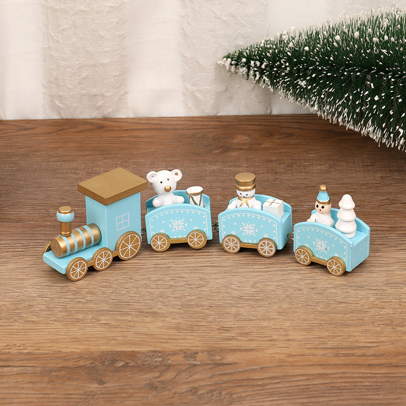 Wooden toy train set with teddy bear and snowman figures on a wooden surface.