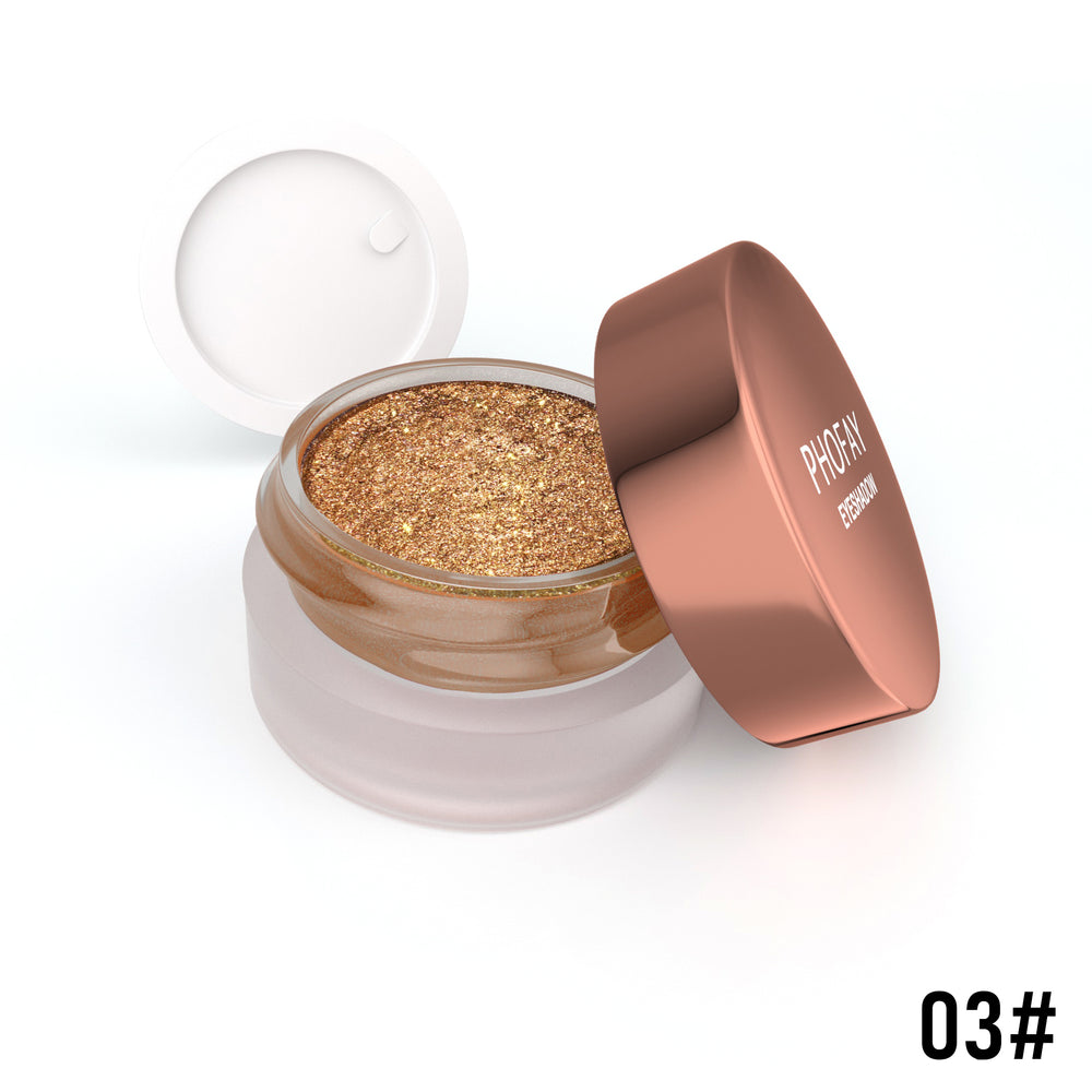 Open jar of gold glittery powder with a rose gold lid on a white background