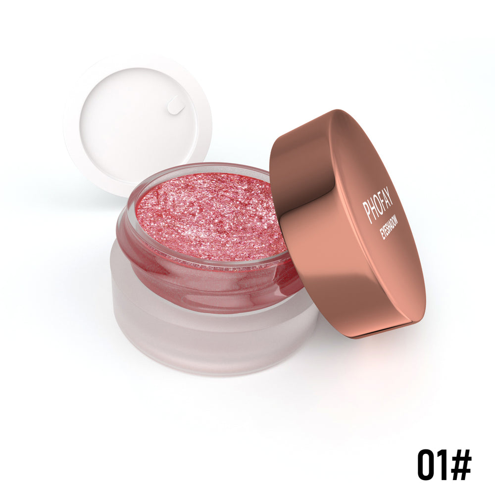 Open jar of pink glittery makeup with a rose gold lid on a white background