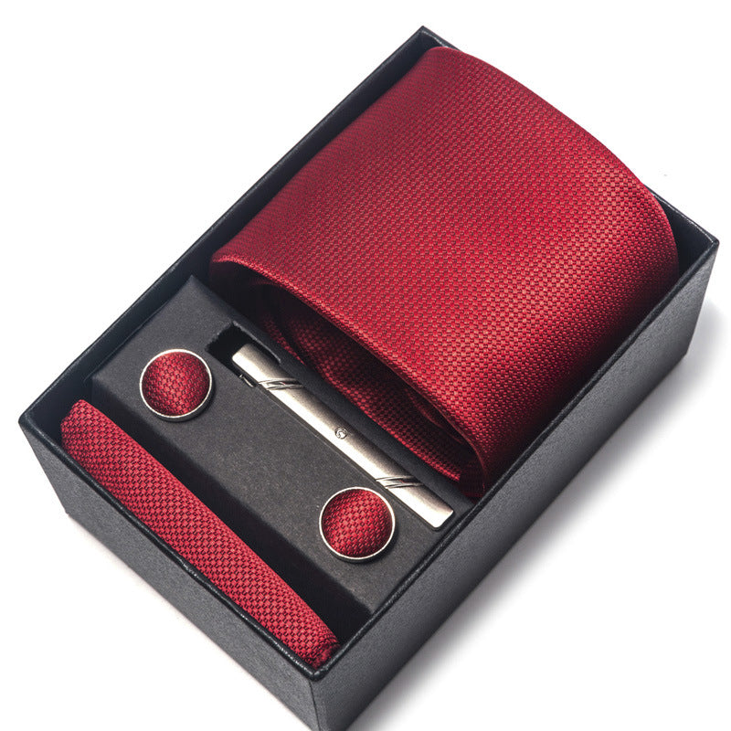 Red tie set with tie clip and cufflinks in a black box on a white background