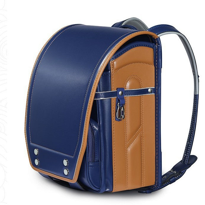 A traditional Japanese-style school backpack in navy blue and tan faux leather, featuring a structured dome shape, front zippered pocket, and padded shoulder straps, shown on a white background.