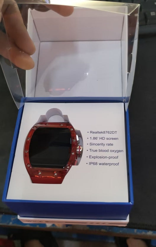 Red smartwatch in a box with specifications on a dark surface