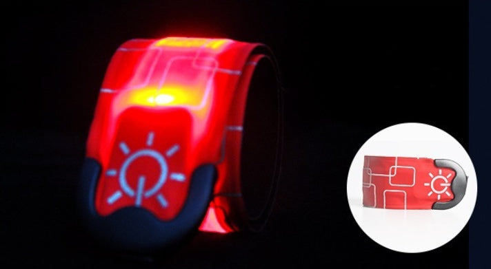 Red and black reflective safety belt with light on a dark background