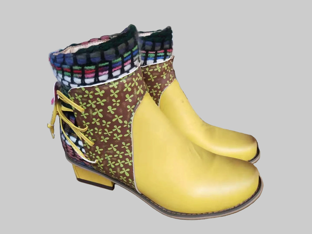 Pair of colorful boots with a yellow sole on a workshop table.