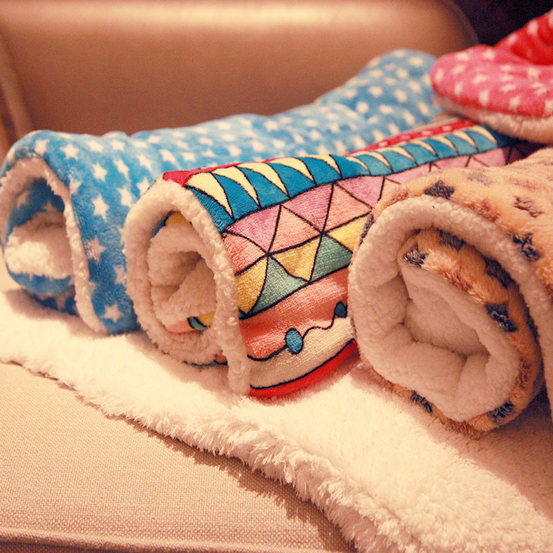 Roll-up fleece blankets with colorful patterns on a soft surface