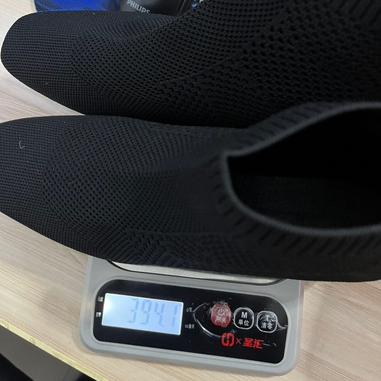 Scarpe nere pesate su una bilancia digitale con sfondo sfocato