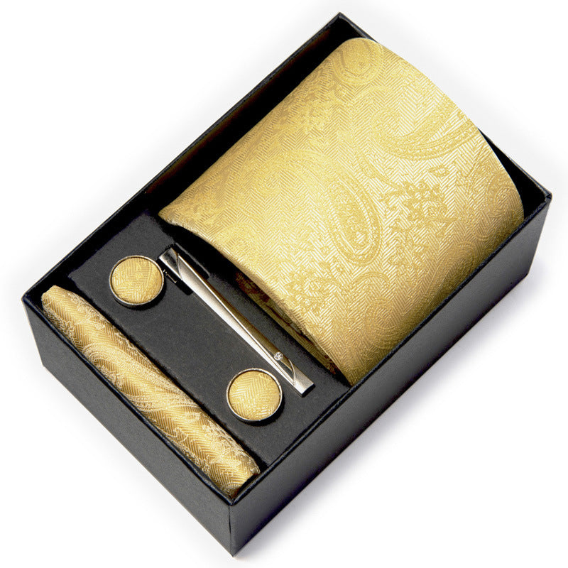 Gold tie set with cufflinks and tie clip in a black box on a white background