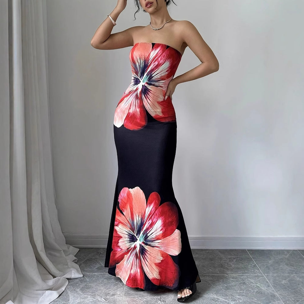 Woman wearing a strapless dress with floral design in a room with curtains and a gray floor.