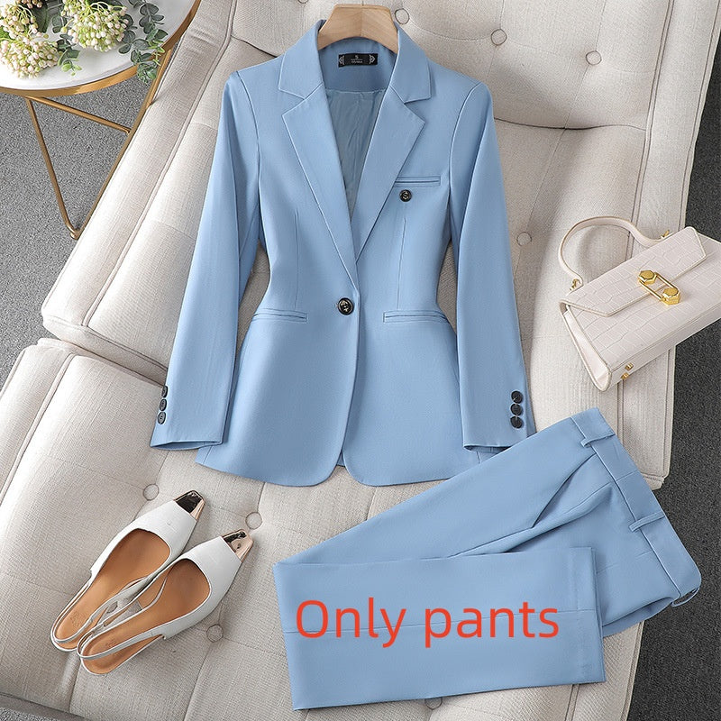 Light blue suit with pants, shoes, and handbag on a gray sofa.