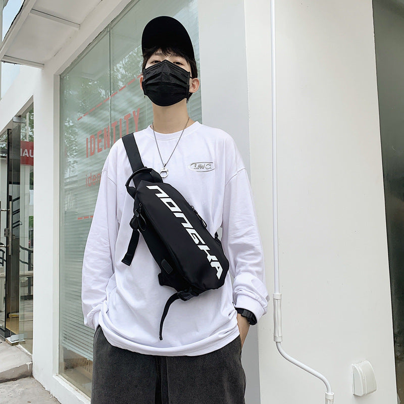 Person wearing a white sweatshirt with a black backpack in front of a store.