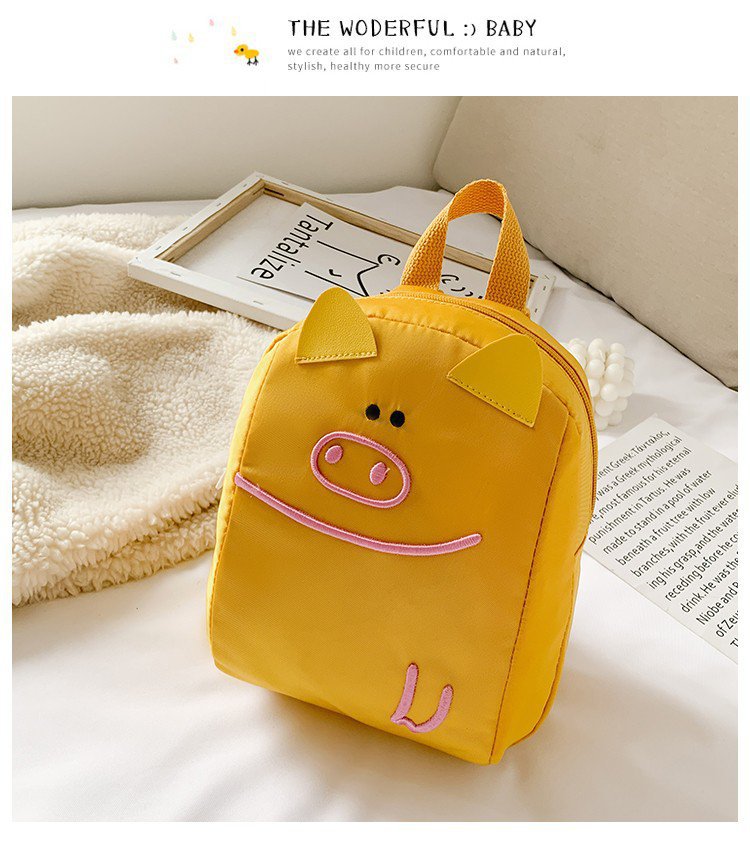 Yellow backpack with pig design on a light surface