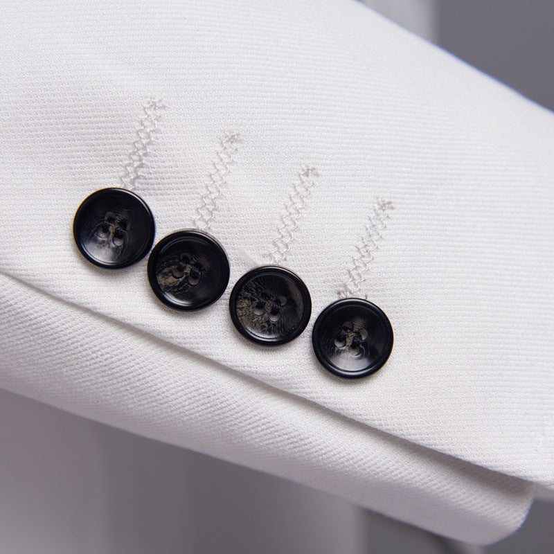 Close-up of a white jacket with black buttons on a light gray background