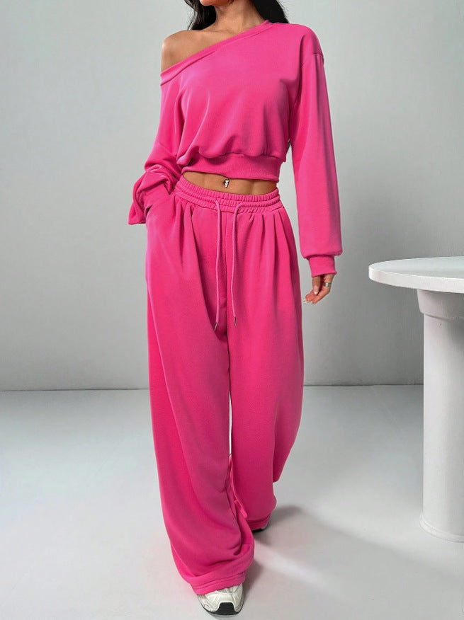Person wearing a bright pink off-shoulder top and matching pants on a plain background