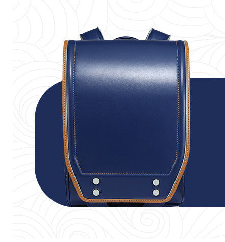 A navy blue leather school backpack with tan leather trim and silver metal rivets, shown from a front-facing perspective on a stylized white background.