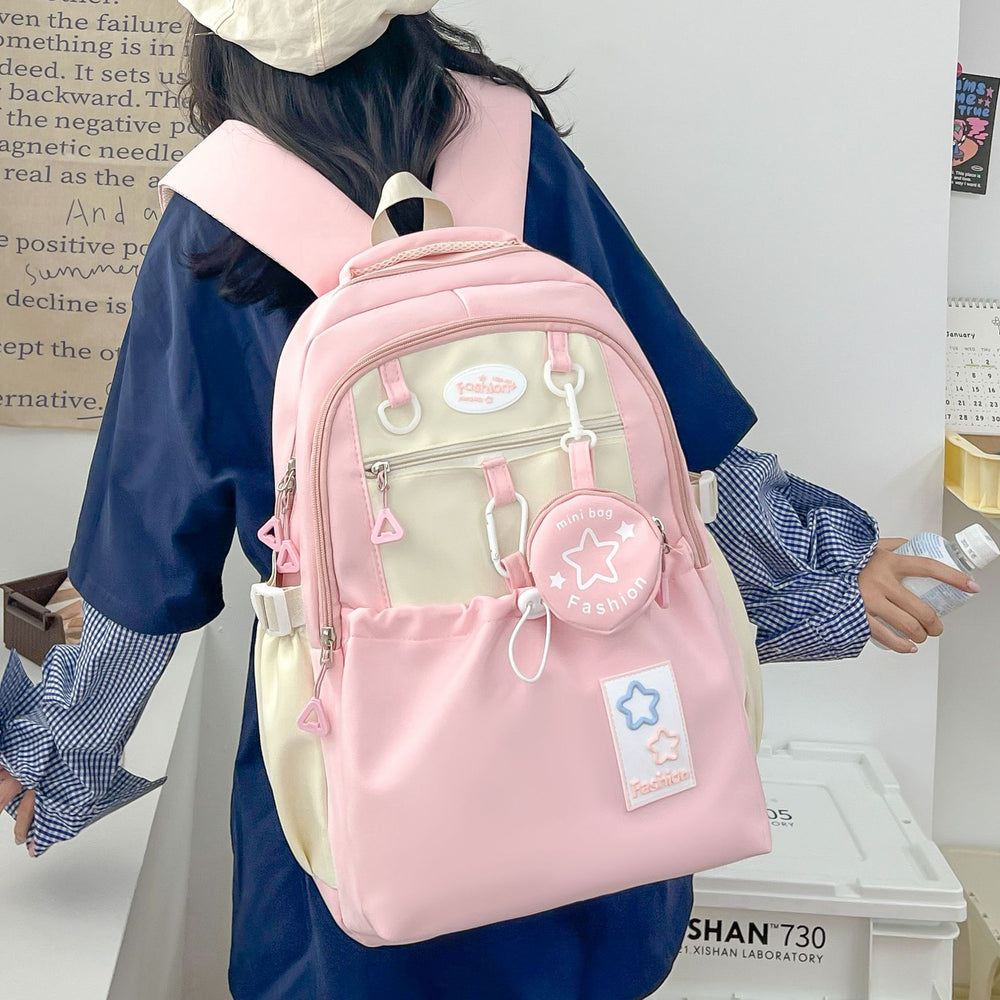 Person wearing a pink and beige backpack with decorative elements.