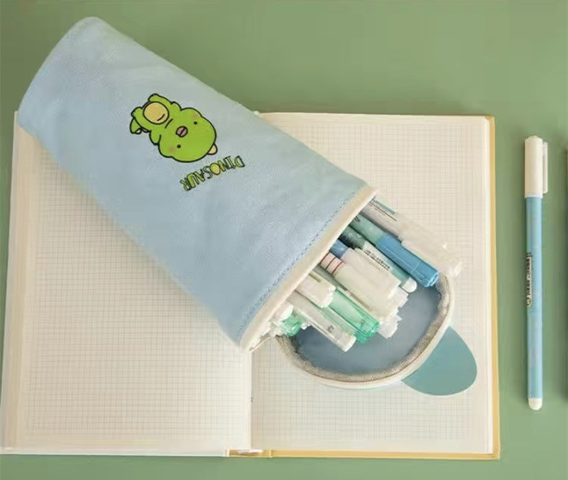 Pencil case with stationery items on a notebook against a green background