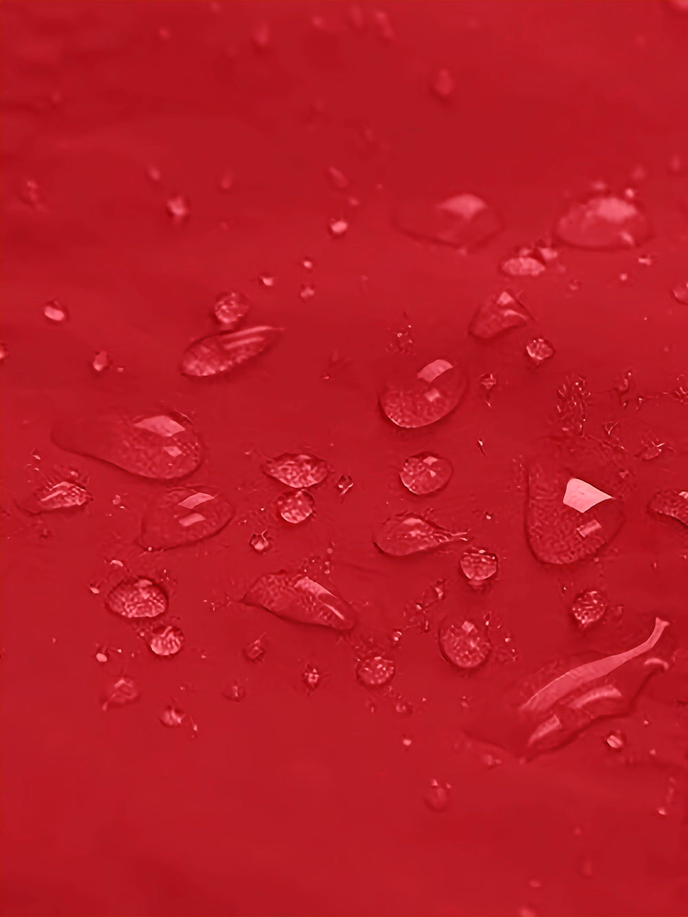 Red surface with scattered clear water droplets, shown as a close-up texture shot.