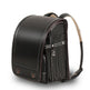 Black leather backpack with visible stitching on a white background