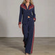 A woman models a matching two-piece western-style lounge set consisting of a long-sleeve button-up shirt and wide-leg pants. The set is navy blue with burgundy panels on the chest and cuffs, accented with white western embroidery on the shirt collar and shoulders, and white side stripes on the pants.