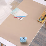 Beige desk pad on a desk with stationery items