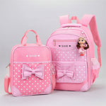 Pink polka dot backpack and lunch bag set with bow details on a white background