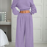 Person wearing a purple outfit in a bedroom setting