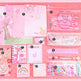 Set of stationery items including notebooks, stickers, and clips on a pink background