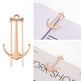 Rose gold anchor-shaped earrings on a white background
