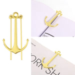 Gold anchor-shaped pins on a white background