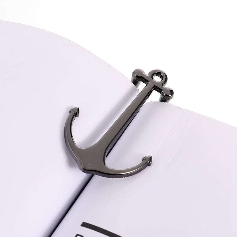 Metallic anchor-shaped object on a white surface