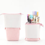 Pink and white pencil case with stationery items on a white background