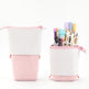 Pink and white pencil case with stationery items on a white background