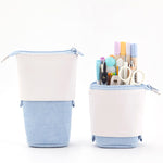 Two cylindrical pencil cases with stationery items on a white background
