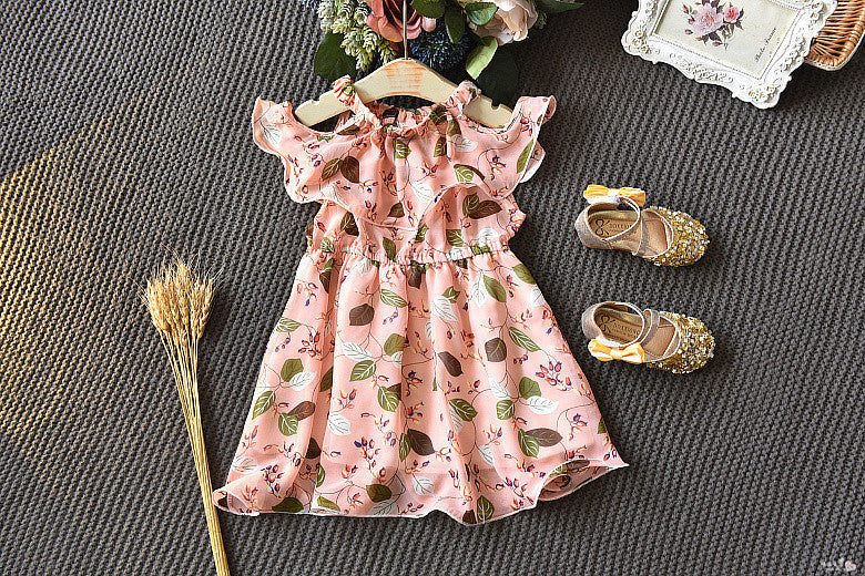 Pink floral dress with matching shoes on a textured surface