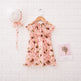 Pink floral dress with matching headband on a textured white background