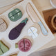 Wooden toy set of vegetables and a knife on a white board, branded 'nurukids'.