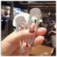 Hand holding two sparkling hair clips with a blurred indoor background