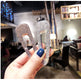 Hand holding two sparkling hair clips with a blurred indoor background