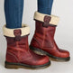 Red boots with cream fur lining worn with blue jeans on a light background