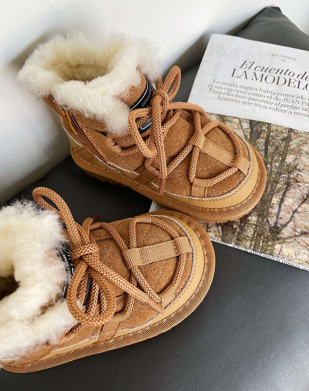 Pair of brown winter boots with fur lining on a surface.