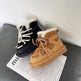 Black and brown winter boots with fur lining on a newspaper.